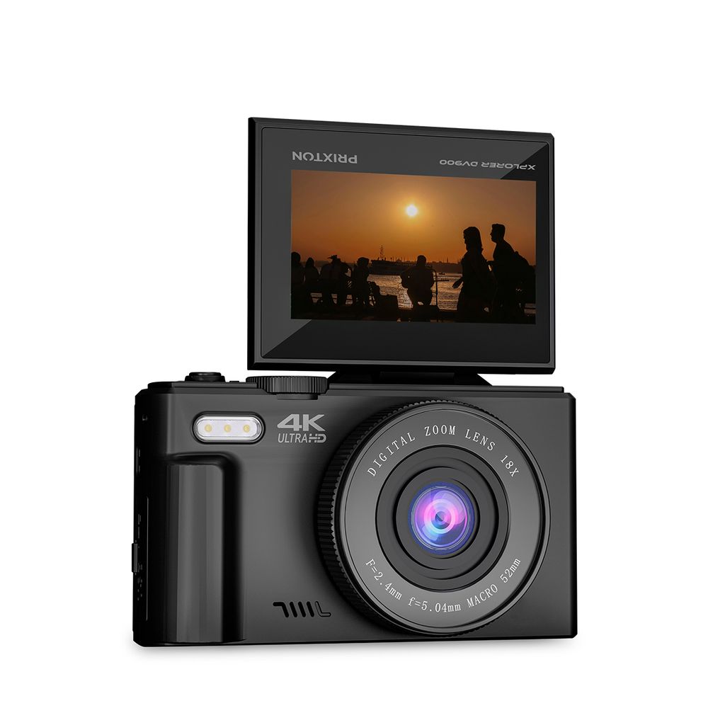 A black digital camera with its screen flipped up, showing a sunset scene.