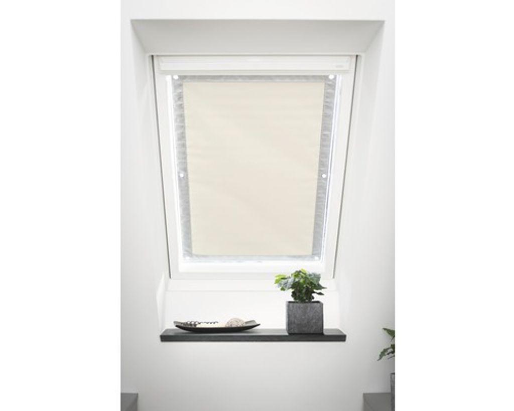 A skylight window with a beige roller blind installed.