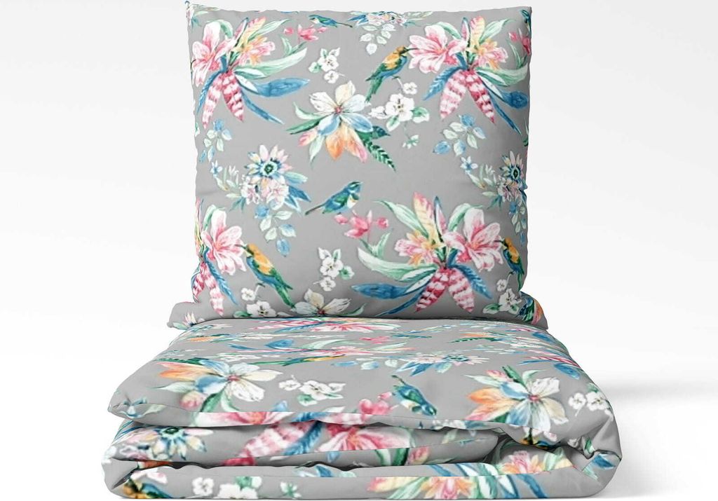 A folded bedding set and a pillow with a floral and bird pattern on a gray background.