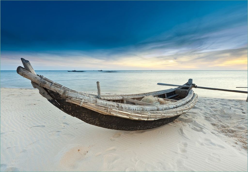 Wallario Fototapete Vliestapete, seidenmatte Oberfläche, einfache Verarbeitung, Größe 300 x 210 cm, Motiv Fischerboot am Strand mit Sonnenuntergang