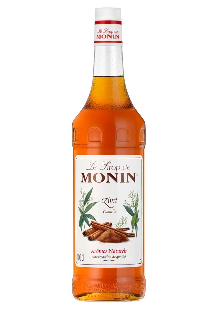A bottle of Monin Cinnamon syrup against a white background.