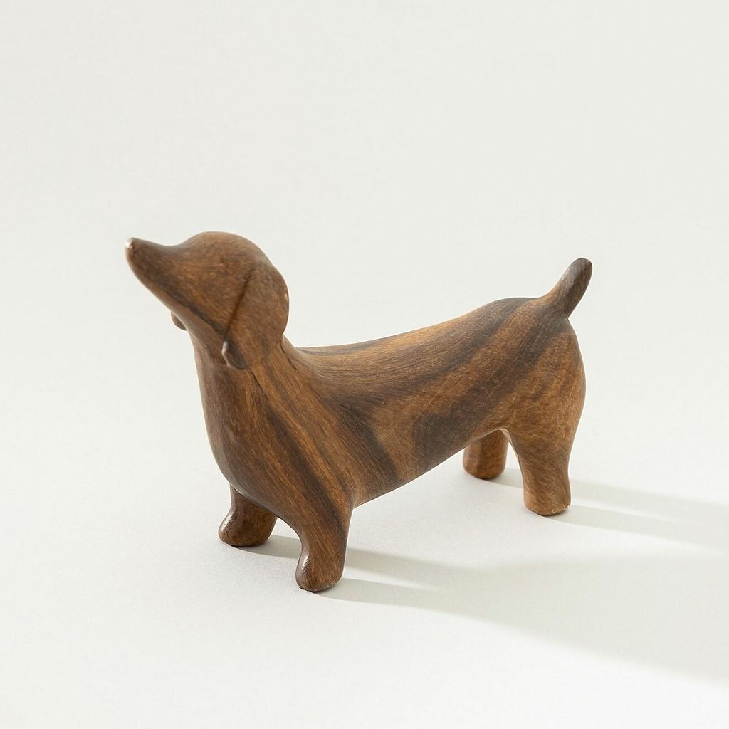 A wooden dachshund figurine on a white background.