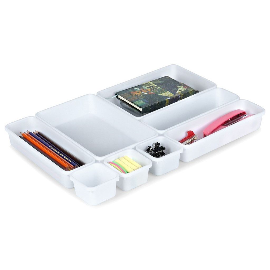 A set of modular white drawer organizers filled with office supplies.
