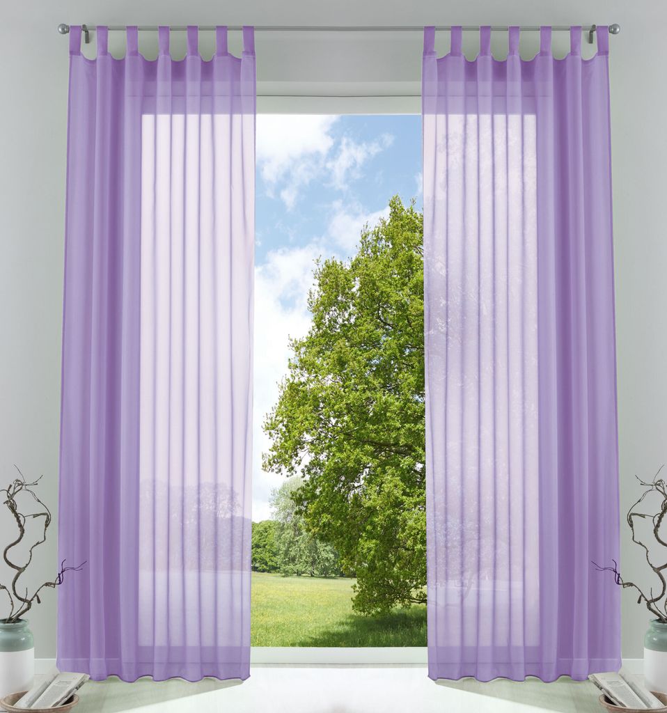 A pair of sheer purple curtains hangs in front of a window, revealing a green tree and blue sky outside.