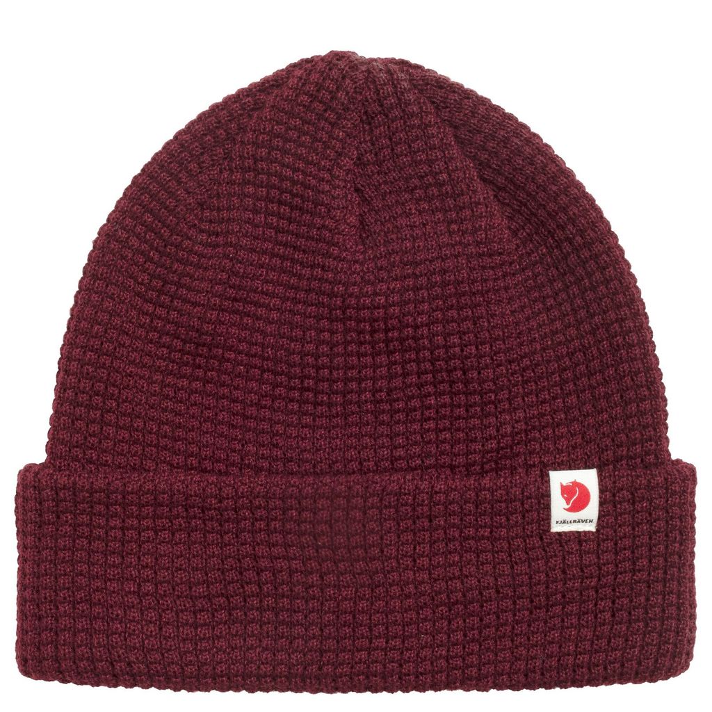 A maroon knitted hat with a small white logo patch on the front.