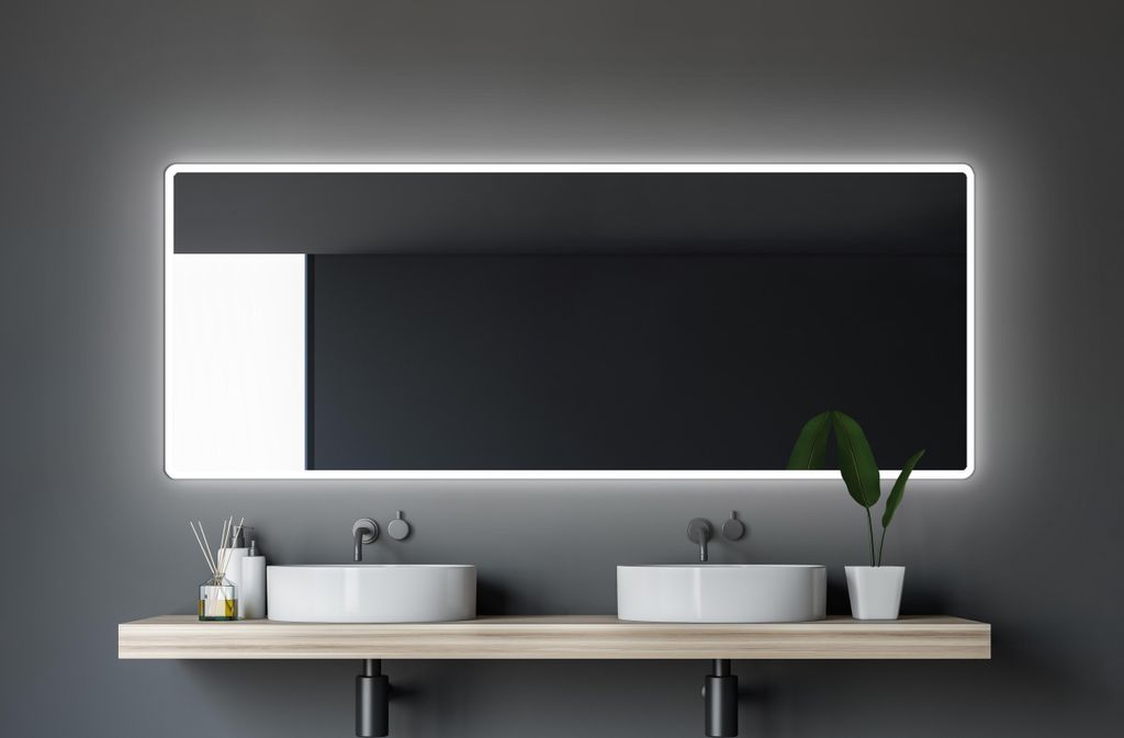 A modern bathroom vanity with two sinks and a large illuminated mirror.