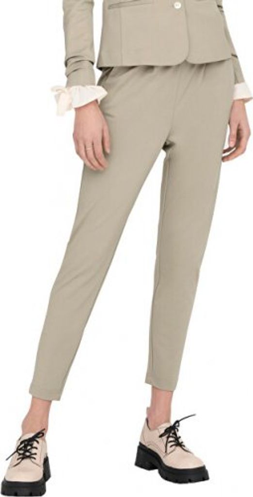 A person wearing beige pants and a beige jacket, standing against a white background.
