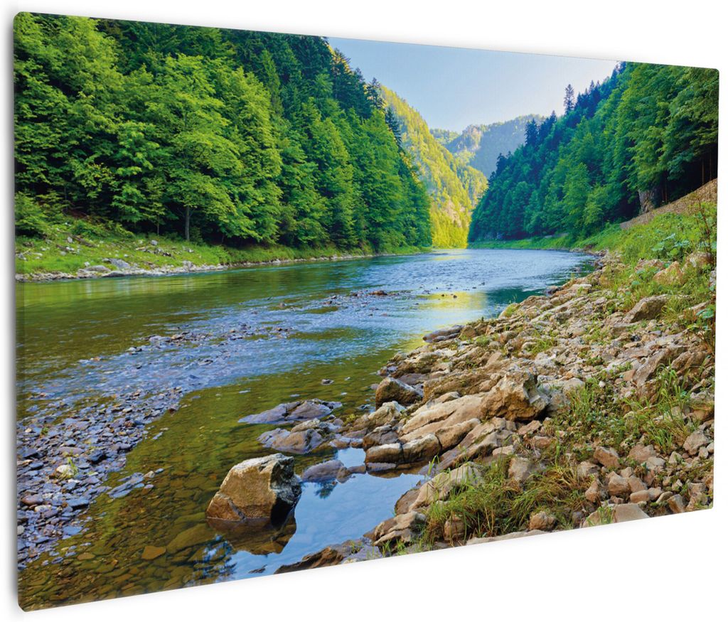Wallario Premium Leinwandbild Fluss in den Bergen an steinigem Ufer in Größe 60 x 90 cm