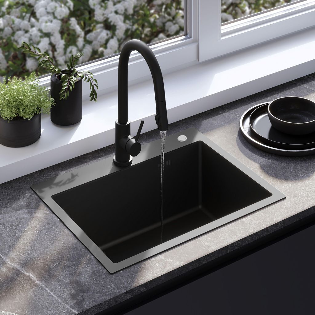 A modern kitchen sink with a black faucet and a black sink, set against a window with blooming flowers outside.