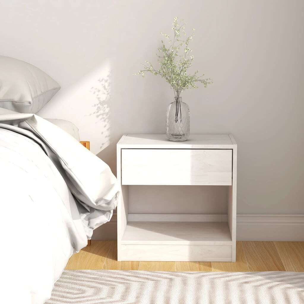 A white nightstand next to a bed with white bedding.