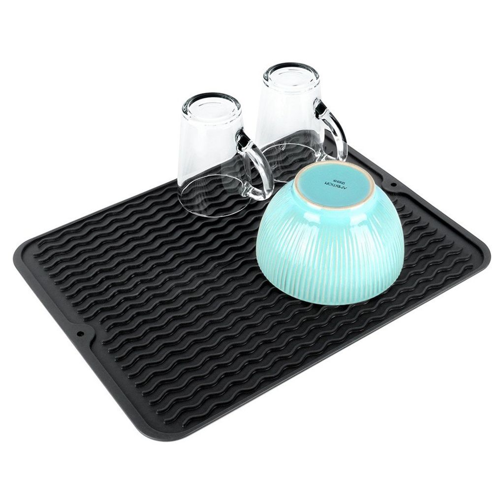 A black silicone dish drying mat with a wavy pattern is shown with two clear glasses and a blue bowl placed on it.