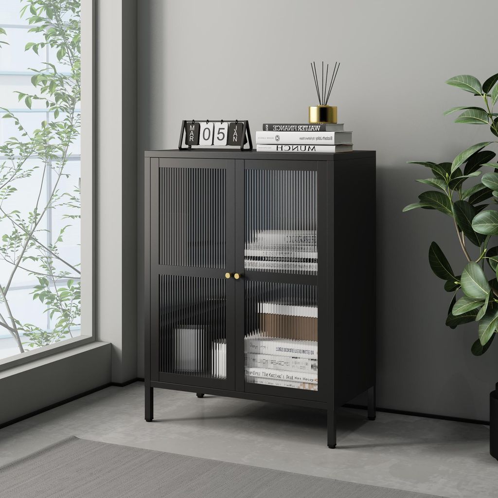 A black sideboard with fluted glass doors is placed in a room with a large window and a plant.