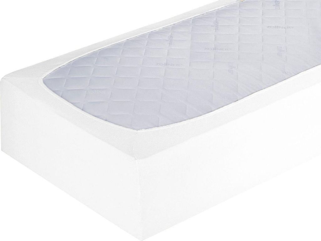 A close-up, angled view of a white fitted sheet with a quilted pattern on top.