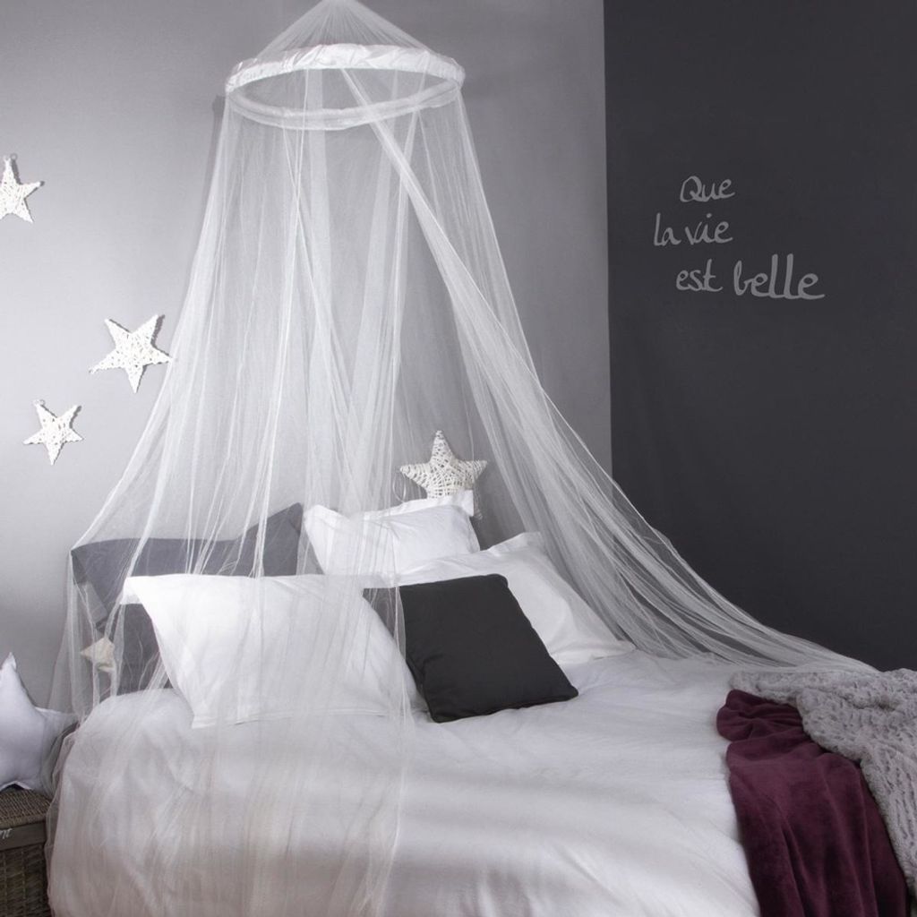 A bedroom scene with a bed draped with a canopy and decorated with star motifs.