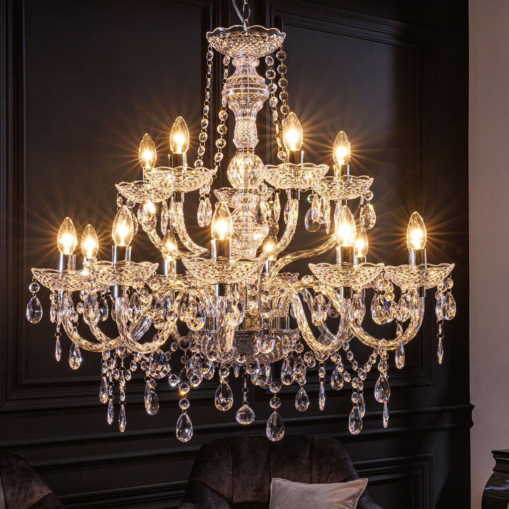 A close-up view of a crystal chandelier against a dark background.