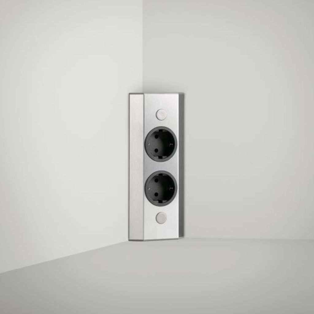 A corner of a room with a wall-mounted electrical outlet.