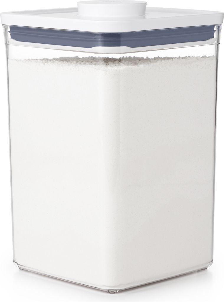 A clear, well-lit studio shot of a square food storage container filled with white powder, likely flour.