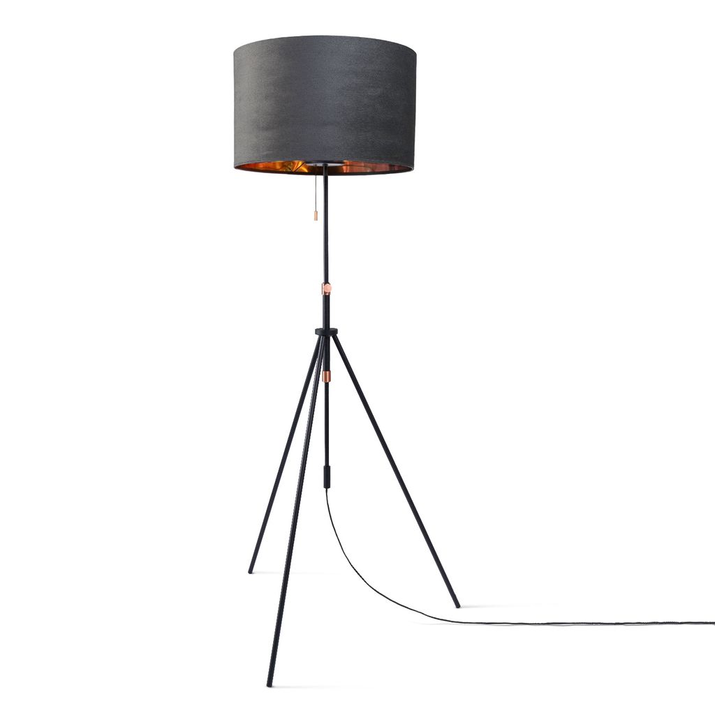 A black tripod floor lamp with a gray drum shade and gold interior.