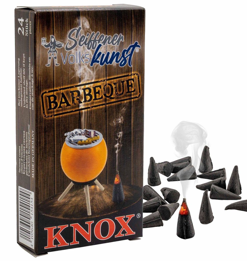 Auf dem Bild ist eine Verpackung von Räucherkerzen der Marke Knox zu sehen die für Barbecue-Duft sorgen und daneben liegen einige der kegelförmigen Räucherkerzen während eine davon raucht.