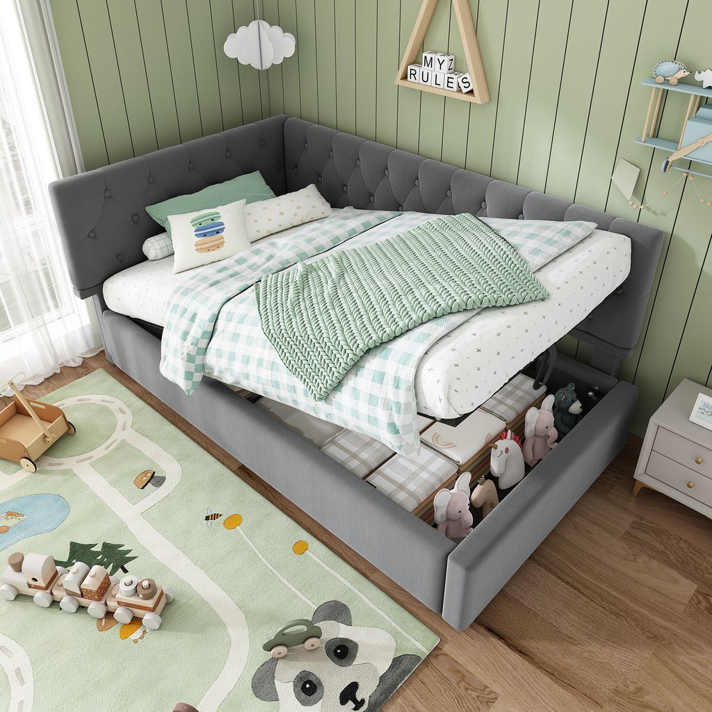 A child's bedroom with a grey corner daybed, featuring storage drawers, a green and white checkered comforter, and a green knitted throw. A colorful pillow and a bolster pillow are on the bed. A rug with a panda and a race track design is on the floor, wit