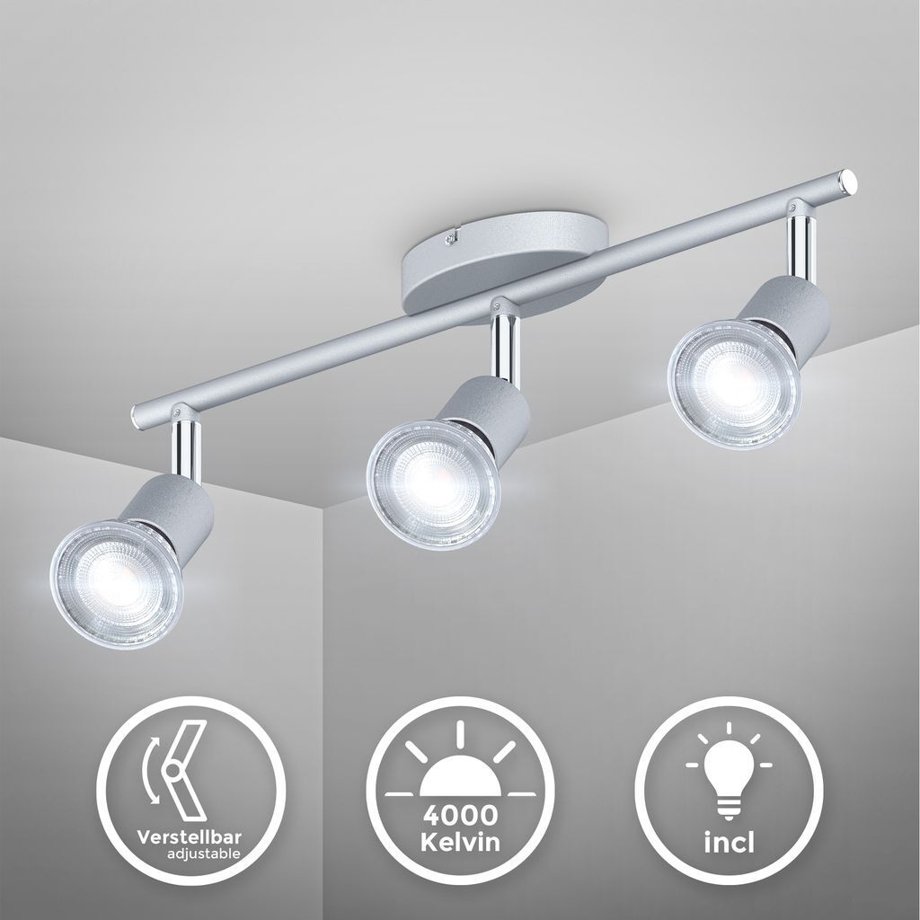 A silver-colored ceiling spotlight with three adjustable heads is mounted on a white ceiling.