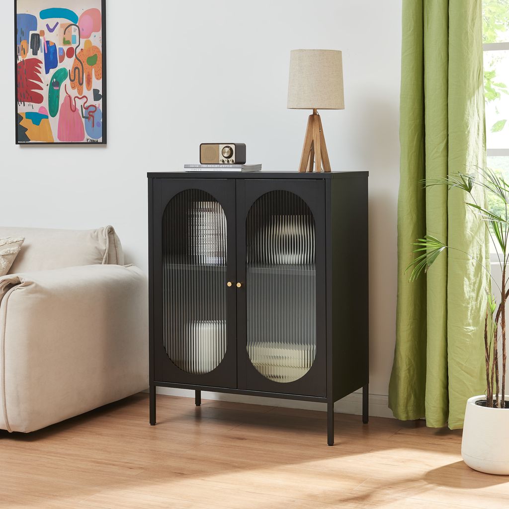A black cabinet with fluted glass doors is displayed in a living room setting.