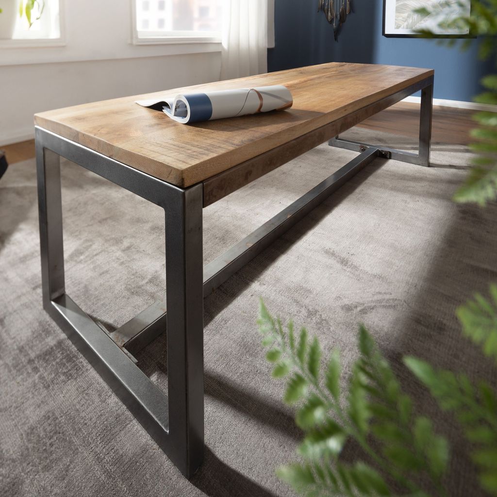 A wooden bench with a metal frame in a room setting.