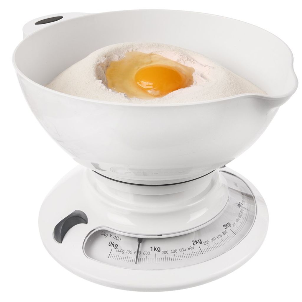 A white mechanical kitchen scale with a bowl containing flour and an egg.
