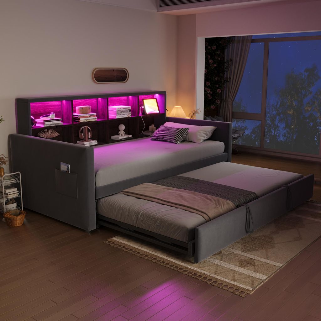 A bedroom scene at night with a daybed pulled out and illuminated by pink LED lights.