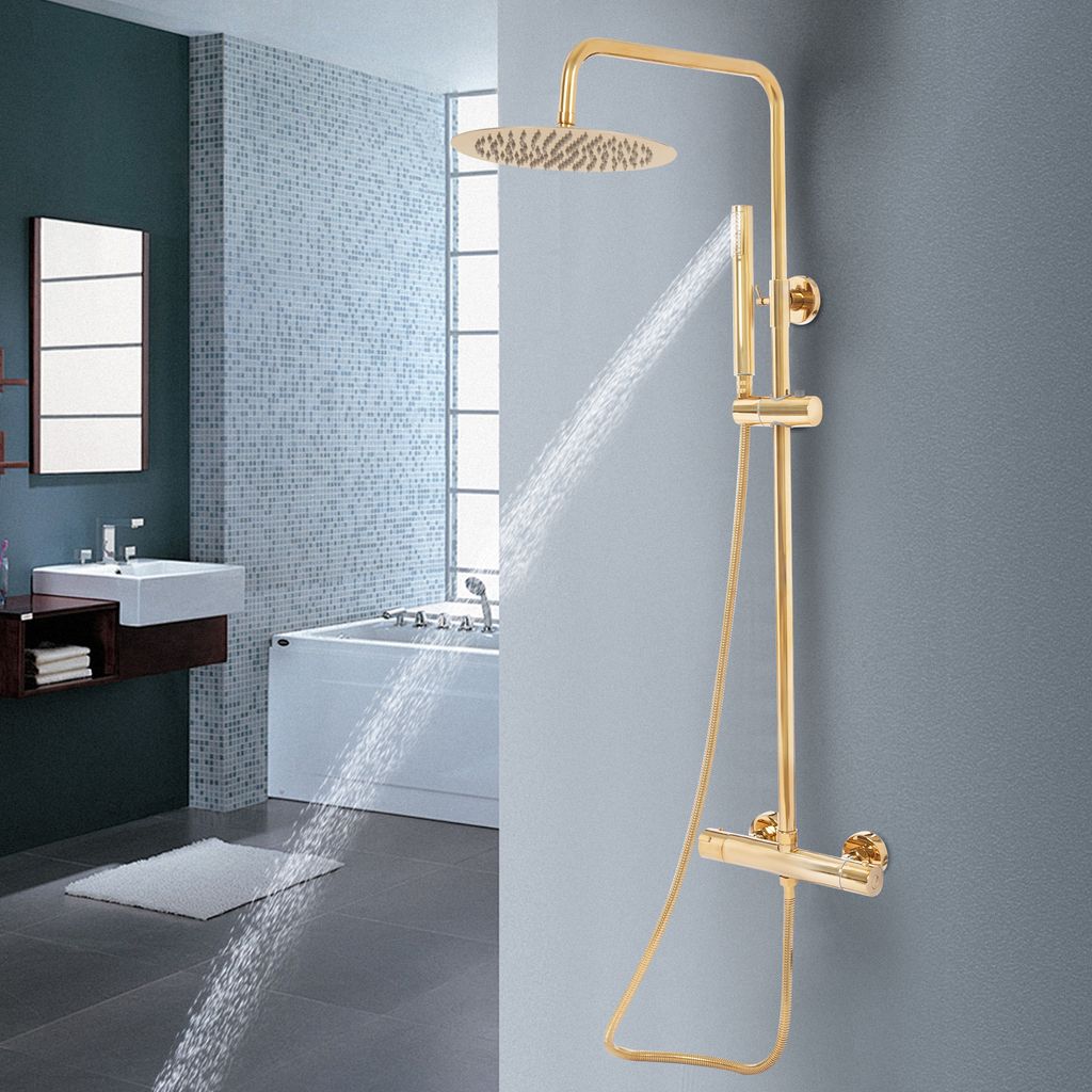 A modern bathroom with a gold shower system in use, showing water spraying.