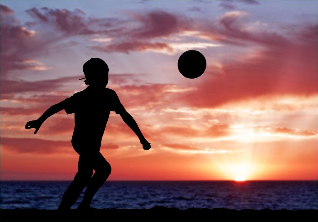 Wallario selbstklebendes Poster - Fußball - Kleiner Junge spielt im Abendrot, Größe: 70 x 100 cm