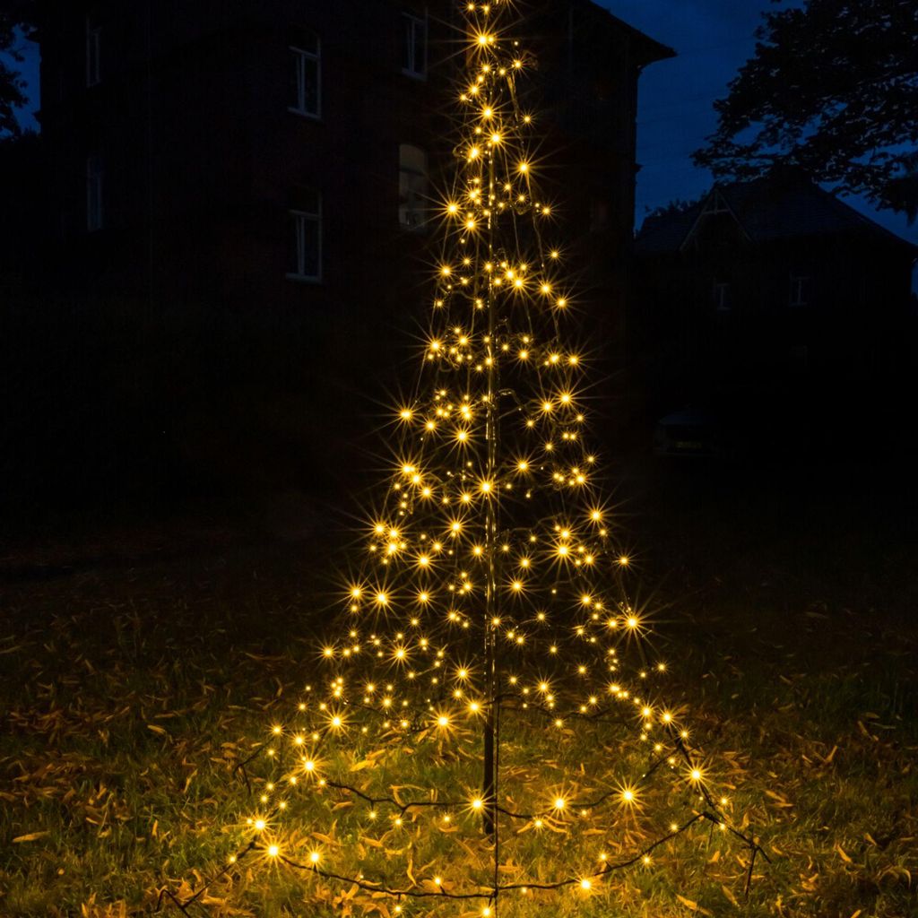 A decorative LED Christmas tree illuminated at night in an outdoor setting.