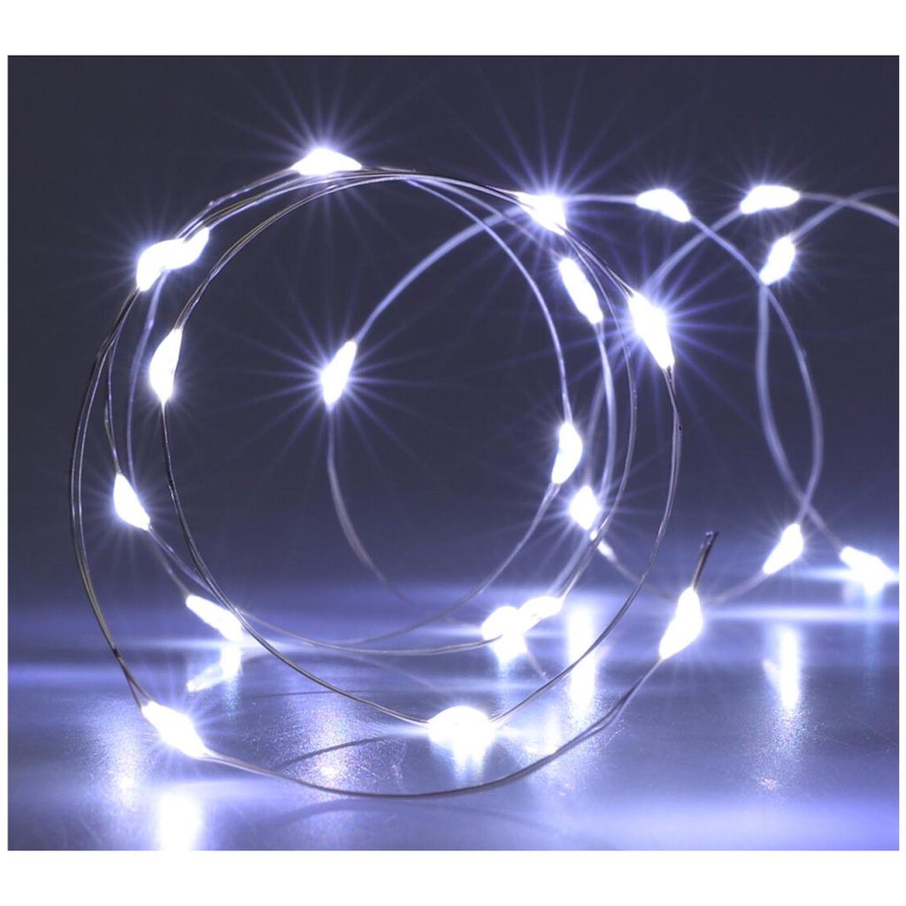 A coiled string of white LED lights on a reflective surface.