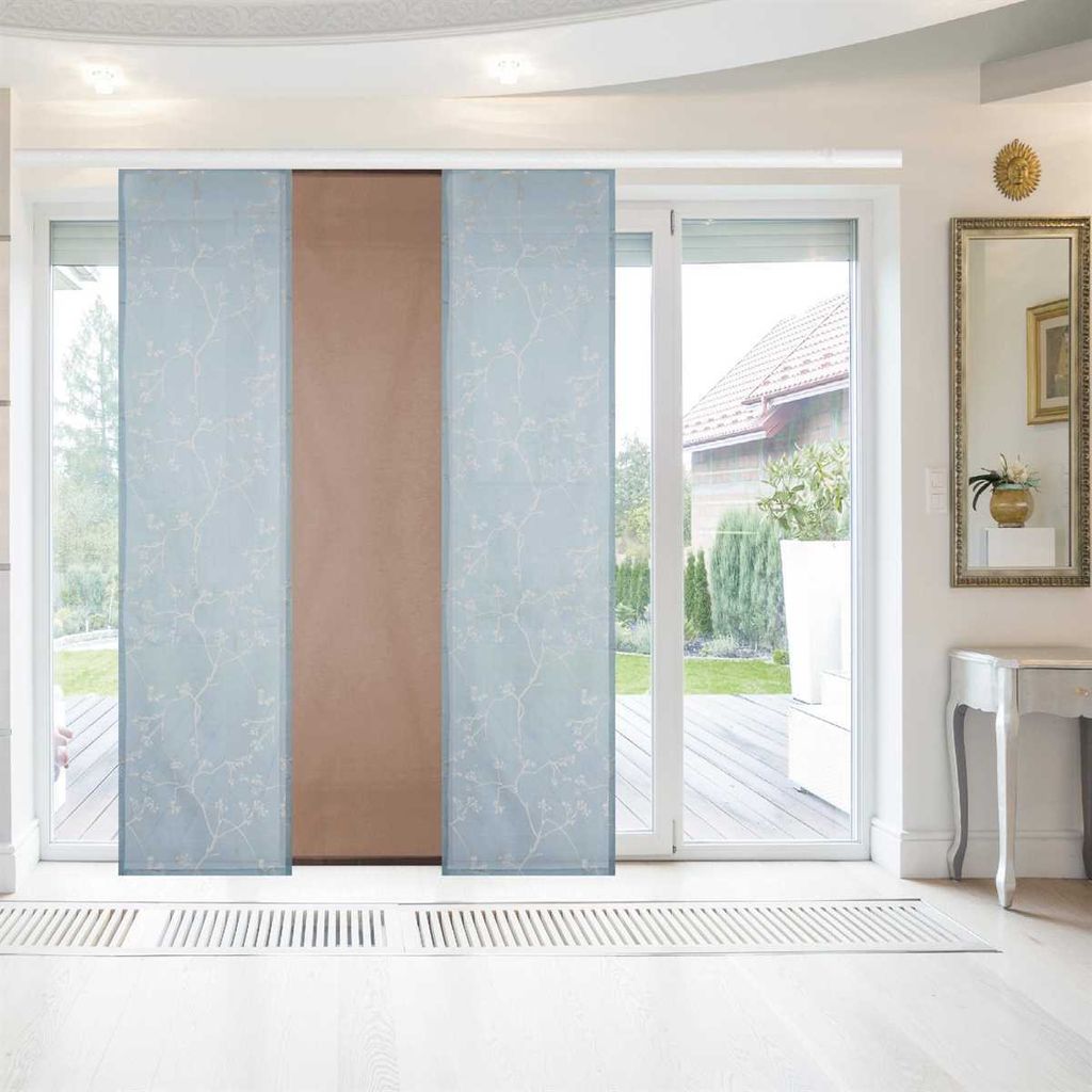 Panel curtains covering a sliding glass door, with a view of a backyard through the glass.