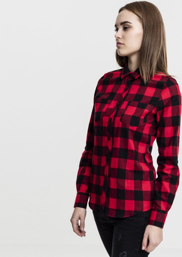 A woman is shown from the side wearing a red and black checkered flannel shirt.