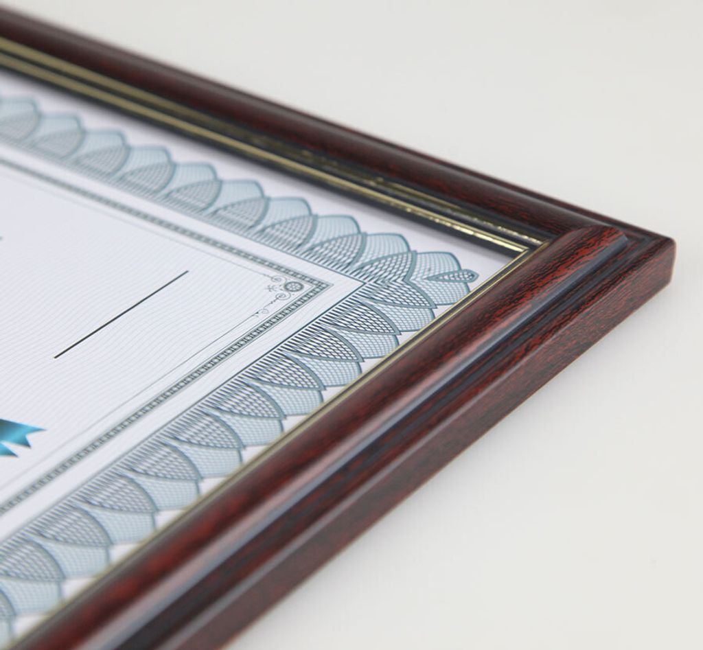 A close-up, angled view of a framed document, likely a certificate or diploma, on a white background.