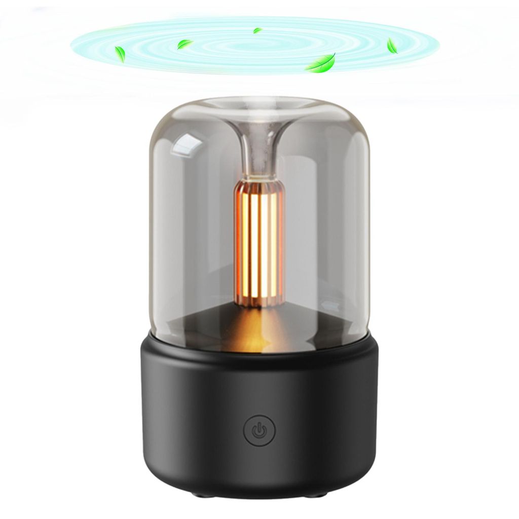 A product shot of a black and clear aroma diffuser with a gold element inside, set against a white background. There are stylized green leaves and blue swirls above the diffuser, suggesting air circulation or fragrance diffusion.