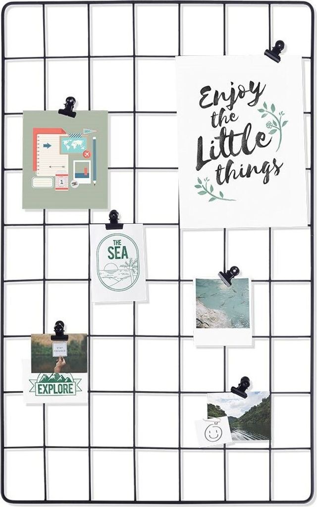 A black metal grid board displaying various photos and cards attached with clips.