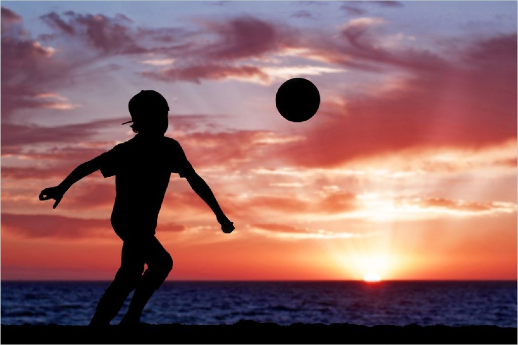 Wallario Poster - Fußball - Kleiner Junge spielt im Abendrot, Kunstdruck Größe: 61 x 91,50 cm