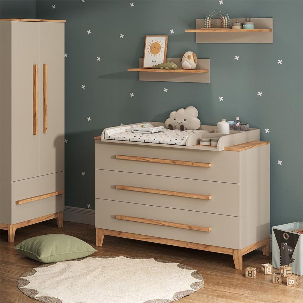 A nursery room with a changing table, wardrobe, and decorative elements.
