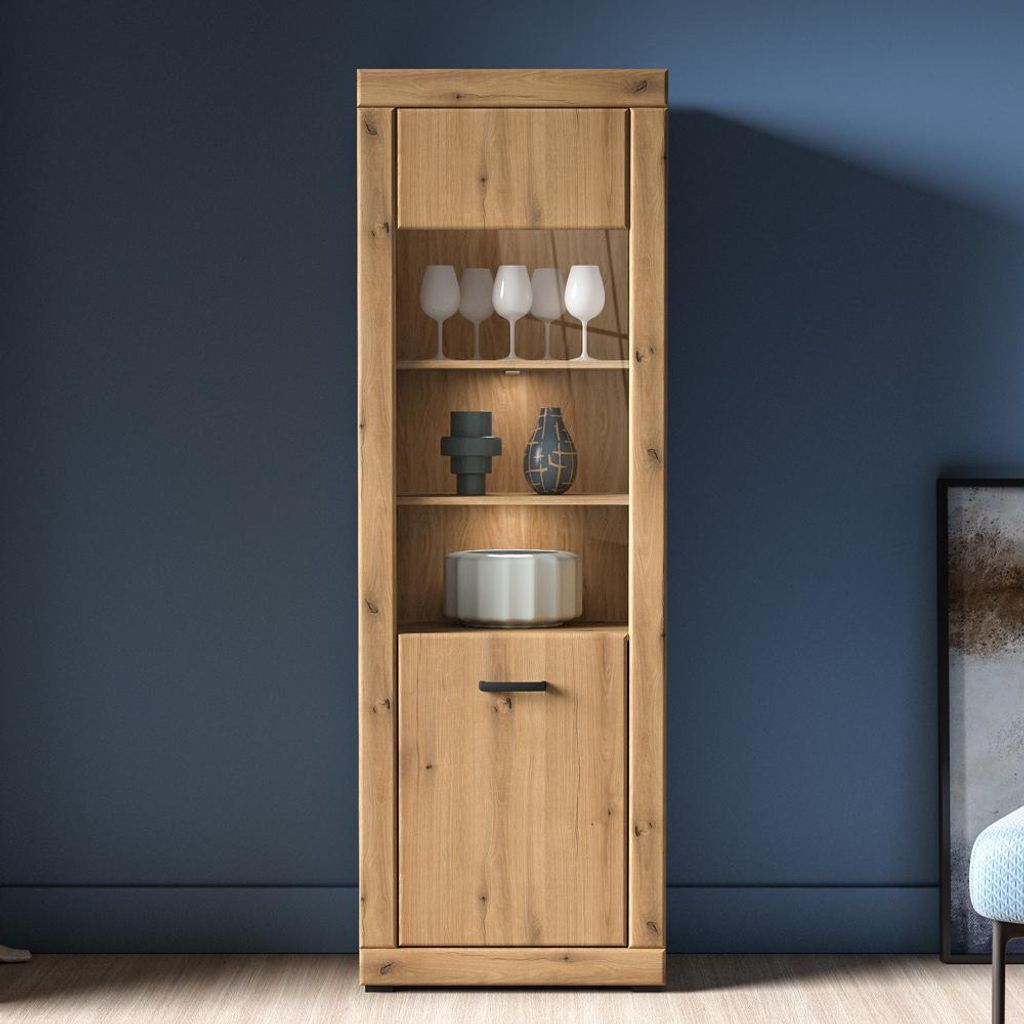 A wooden display cabinet with glass shelves and a drawer, set against a blue wall.