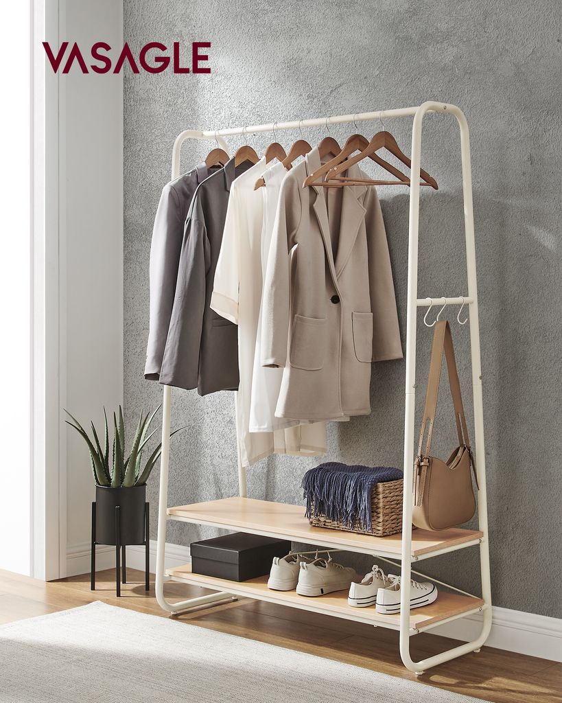A clothing rack with clothes, bags, and shoes, set against a textured gray wall.