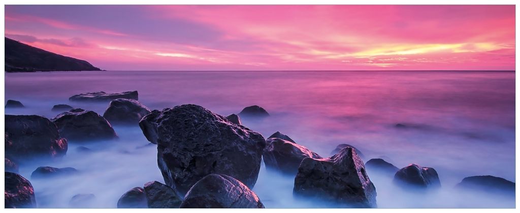 Wallario Wandbild aus Acryl, 200 x 80 cm, freischwebende Optik - Felsen im Meer bei Sonnenuntergang
