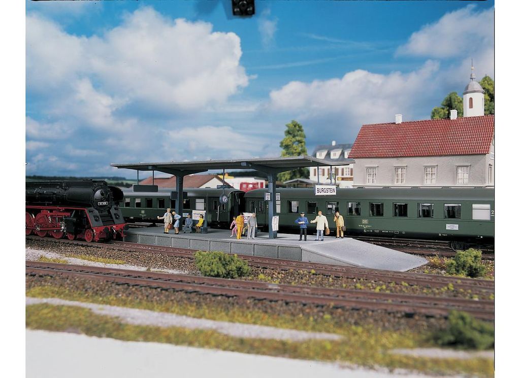 A model train station scene with trains, platforms, and miniature people.