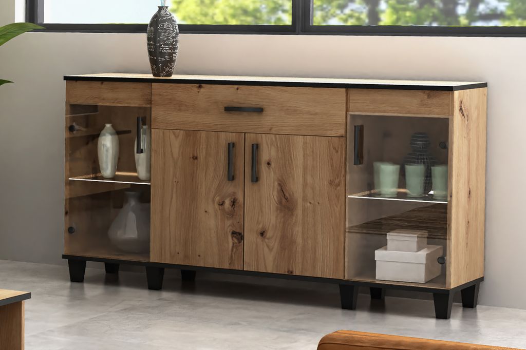A wooden sideboard with glass doors and a drawer, displayed in a room setting with subtle decor.