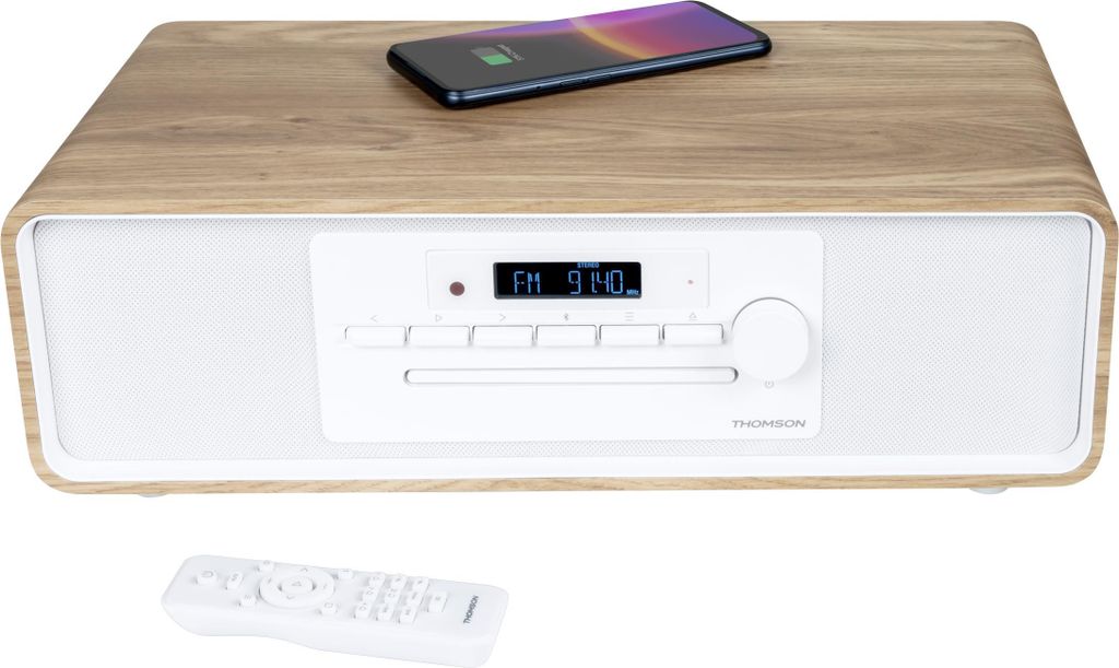 A Thomson Micro-Kompaktanlage MIC301IBT with a smartphone charging on top, and a remote control in the foreground.