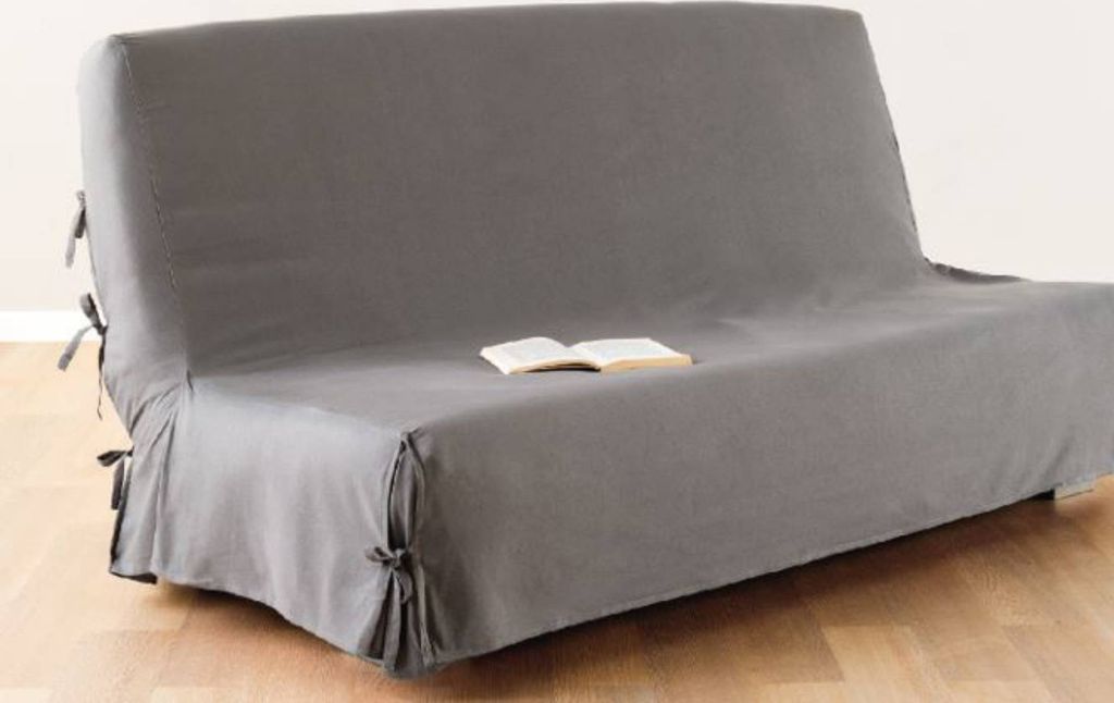 A grey sofa cover is shown on a sofa, with a book placed on top.