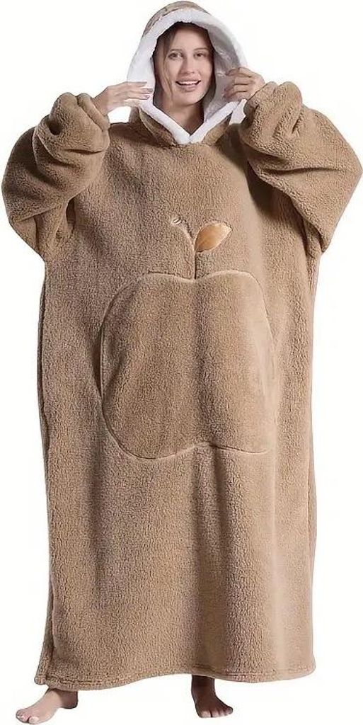 A woman wearing a large, hooded blanket with an apple design.