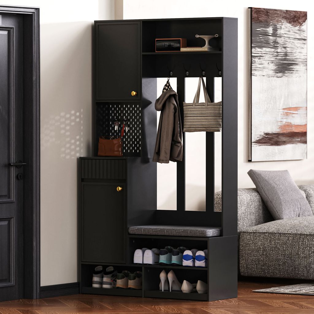A black entryway cabinet with a bench and shoe storage, placed in a room next to a door and a sofa.