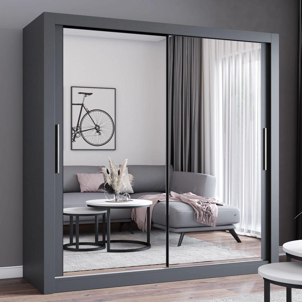 A modern living room scene with a large grey wardrobe with mirrored doors, reflecting a sofa and coffee table.